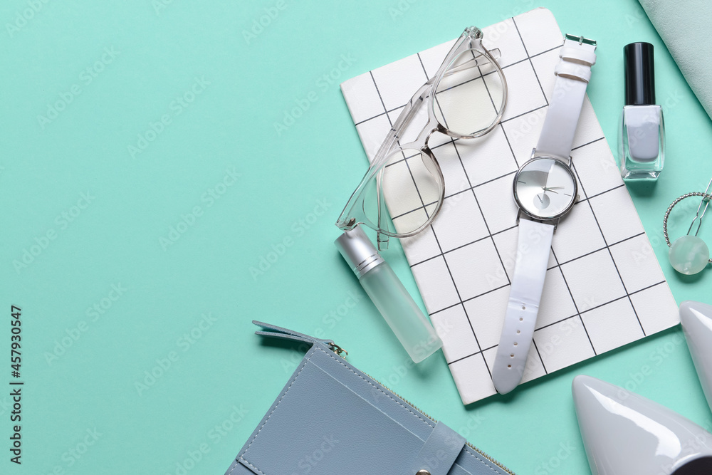 Stylish female accessories on turquoise background