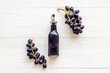 Bottle of balsamic vinegar with bunch of fresh grapes