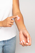 Allergic reaction, itch, allergy, dermatiti concept. Close up of woman applying cream or ointment on swell reddened skin after insect mosquito bites, isolated on grey studio background. 