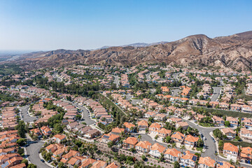 Wall Mural - Aerial view of modern homes surrounded by hills on a clear day.