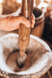 A man miller baker grinds grain by hand in a wooden mortar using old technology