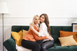 © diignat - Beautiful mother and adult daughter hugging portrait close up, sitting on couch at home, smiling woman embracing mum, spending leisure time together, two generations good relationship