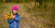 © Ermolaev Alexandr - Happy young girl with down syndrome holds bouquet of autumn leaves. Empty space for text