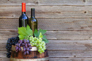 Wall Mural - Various colorful grapes and wine bottles on wine barrel