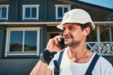 Wall Mural - Builder having a phone call on hot summer day