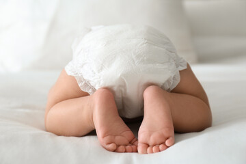 Sticker - Cute little baby in diaper on bed