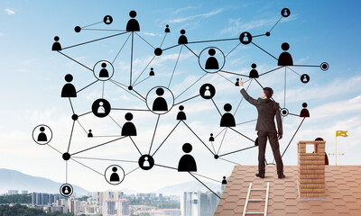 businessman on house roof presenting networking and connection concept. mixed media