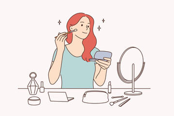 Beauty, skincare and makeup concept. Young pretty girl cartoon character sitting making makeup with brush looking at mirror vector illustration 