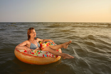 Canvas Print - Happy woman with inflatable ring in sea