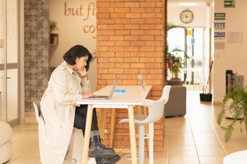 Poster - Beautiful young, short-haired woman working on the laptop.