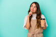 © Asier - Young caucasian store clerk woman holding a takeaway coffee isolated on blue background looking sideways with doubtful and skeptical expression.