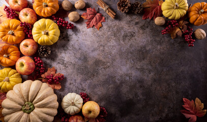 Wall Mural - Autumn composition. Pumpkin, autumn leaves and apple on dark stone background. Flat lay, top view with copy space.