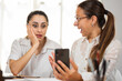 © Facundo - Mujeres de negocio sorprendidas y contentas al observar el celular mientras trabajan en la oficina.