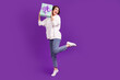 Full size photo of young good mood excited girl dancing with birthday present dreaming isolated on violet color background