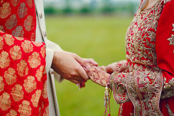 Wall Mural - hindu bride walks behind husband holding garb