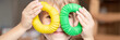 anti stress sensory pop tube plastic toy in kid's hands. a little happy child boy plays with a poptube fidget toy at home. children holding and playing pop tube yellow and green color. banner