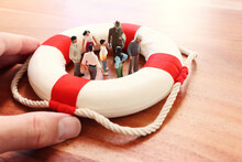 Concept Image Of Life Buoy Protecting Group Of People. Rescue And Support In Times Of Crisis Metaphor