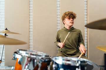 Wall Mural - The boy plays the drums. Lesson at the music school.