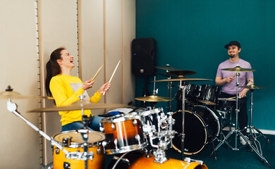 Wall Mural - The girl behind the drum kit laughs. Music lesson with teacher.