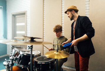 Wall Mural - The teacher shows the boy how to play the drums. Lesson at the music school.