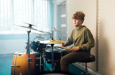 Wall Mural - A boy enjoys music playing the drum set