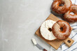 Delicious bagel with cream cheese on light table, flat lay. Space for text