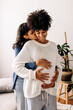 © (JLco) Julia Amaral - Romantic young woman embracing her pregnant wife at home