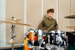 A boy sitting at a drum kit. Lesson at the music school.