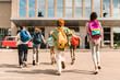 © InsideCreativeHouse - Little kids schoolchildren pupils students running hurrying to the school building for classes lessons from to the school bus. Welcome back to school. The new academic semester year start