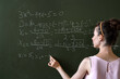 © RomanR - young female student written math formulas on the chalkboard