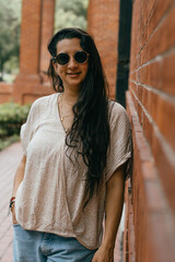 Woman smile feeling good, brick building background.