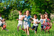 © davit85 - A group of happy children of boys and girls run in the Park on the grass on a Sunny summer day.