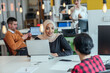 Group of coworkers, teammates helping their new African American, black, muslim colleague wearing hijab to integrate into the modern company. Multiethnic colleagues in a modern startup company.