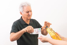 Elderly Man Exchanging 200 Brazilian Reais Bill For A Liter Of Cooking Oil