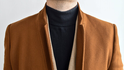 Wall Mural - Detail of men outwear, fashionable mens brown coat combined with black sweater and beige blazer. 