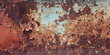 Textured rusty iron sheet background with cracked enamel paint and rust stains