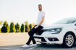 young man with a beard, stands next to the car, Handsome man with a white car