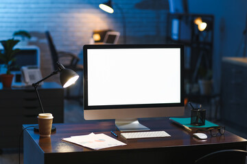 Workplace with modern computer in office at night
