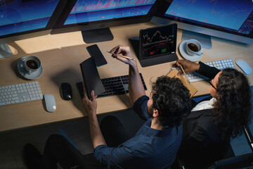 Wall Mural - financial analyst colleague watching realtime financial movement together at night