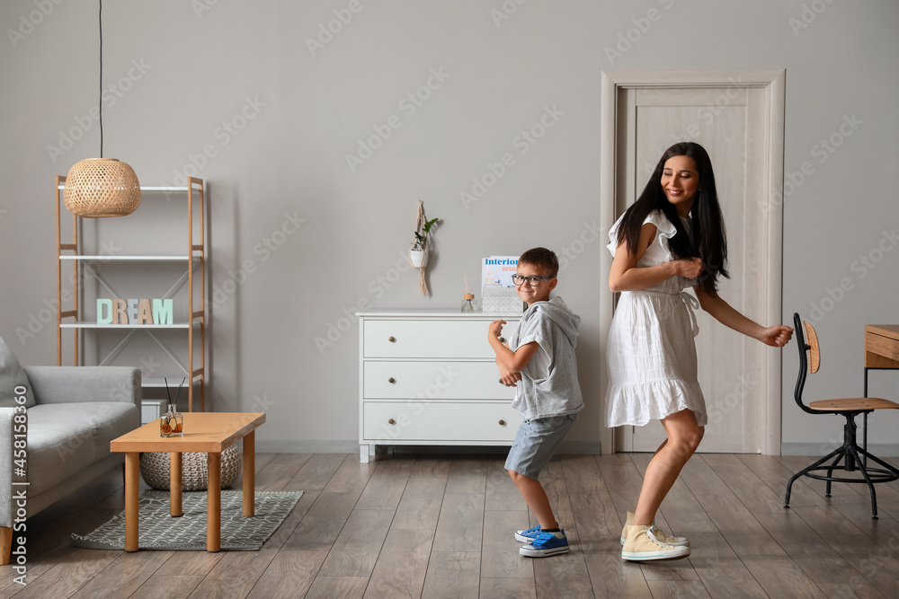 Young woman and her little son dancing at home