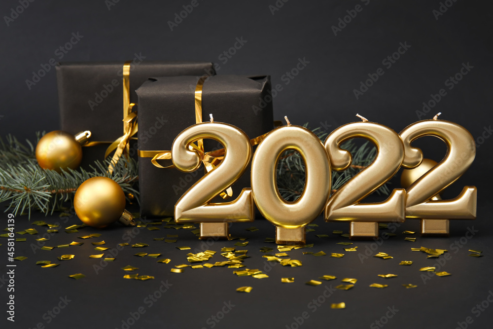 Figure 2022 with gift boxes and confetti on black background