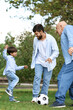 © Pixel-Shot - Man, his little son and father playing football in park