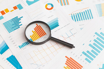 Business graphs, charts and magnifying glass on table. Financial development, Banking Account, Statistics