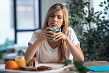 Tred Young Woman Having Breakfast In The Living Room At Home.