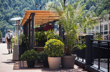 a man walks past a green restaurant in a mountain resort town