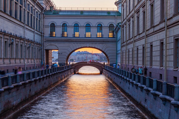 Wall Mural - St. Petersburg, Russia, July 24, 2021. View of the Zimnyaya Kanavka canal connecting the Moika and Neva rivers, the Hermitage bridge and its picturesque embankments at sunset time.