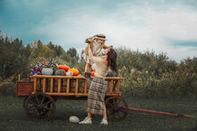 Beautiful Happy Family, Mother And Daughter Together, On A Wooden Cart With Colorful Pumpkins