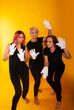 © Marina Chernivetskay - women in white gloves in the image of mimes actress play acting on a yellow background