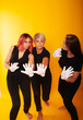 © Marina Chernivetskay - women in white gloves in the image of mimes actress play acting on a yellow background