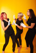 © Marina Chernivetskay - women in white gloves in the image of mimes actress play acting on a yellow background